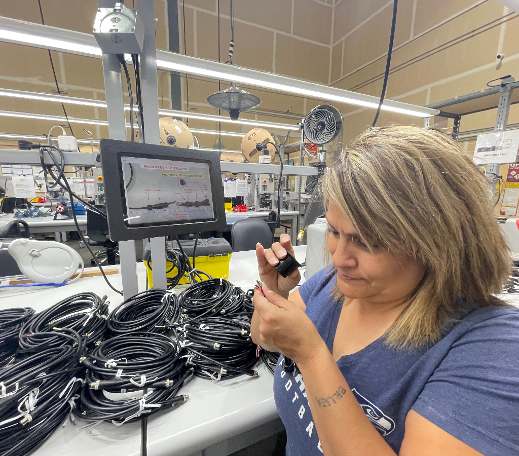 MTI employee inspecting cable assembly with first article image including notes
